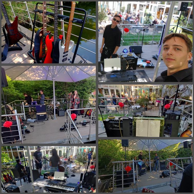 Bandauftritt im Freien mit verschiedenen Instrumenten und einer Zuschauergruppe im Hintergrund.